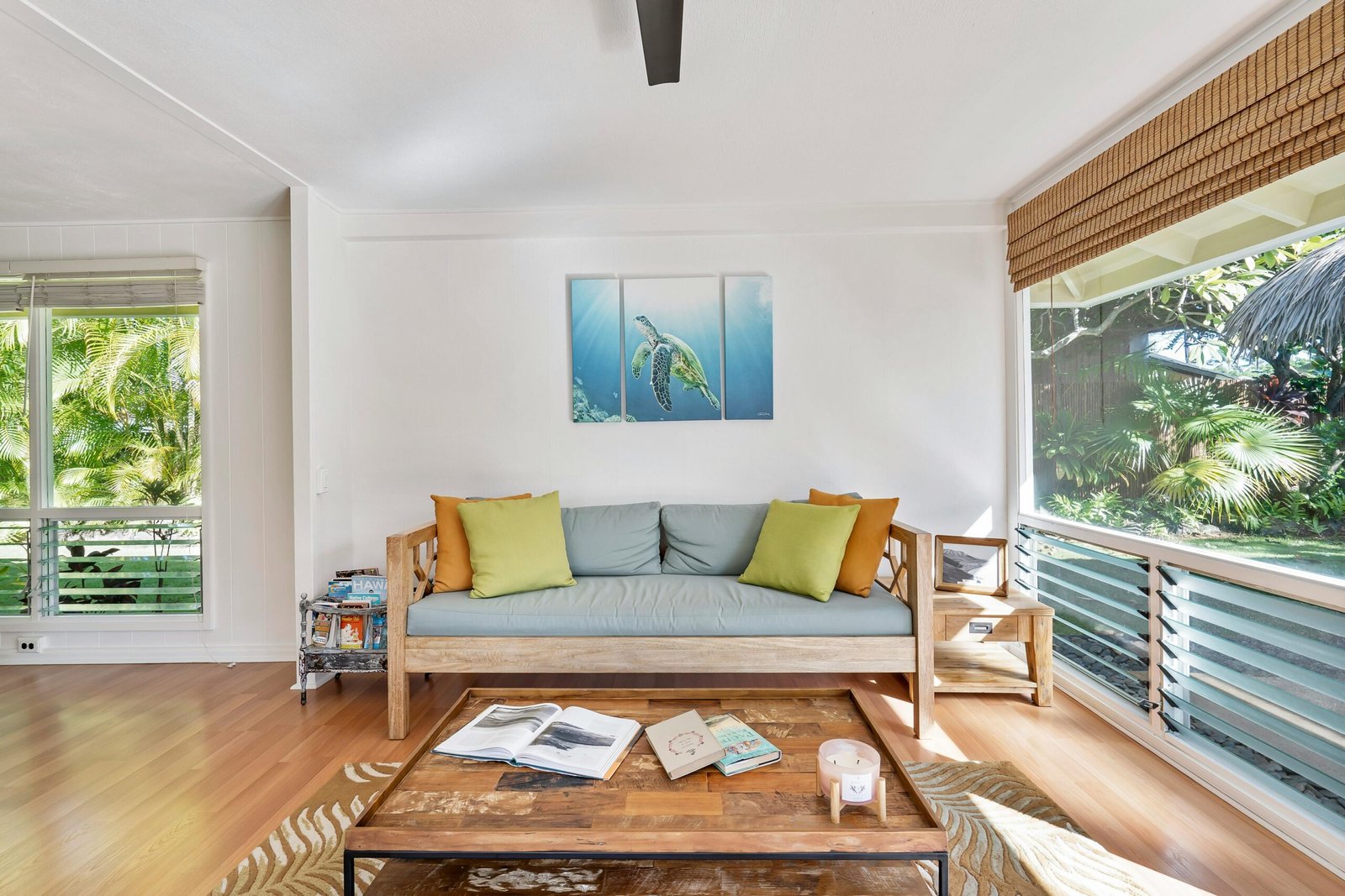a living room that's been staged with a couch and paintings