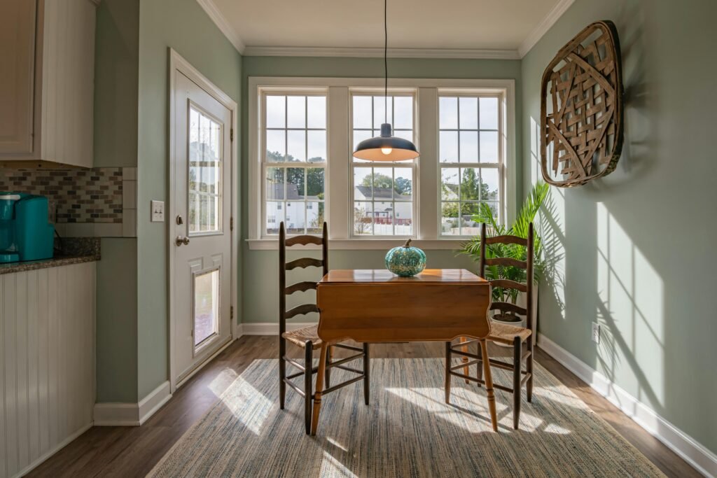 sun lit dining room with wooden tables and chairs with a cozy interior