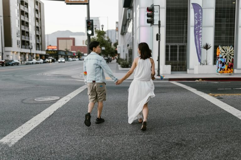 A couple holding hands, walking down an intersection in the San Gabriel Valley